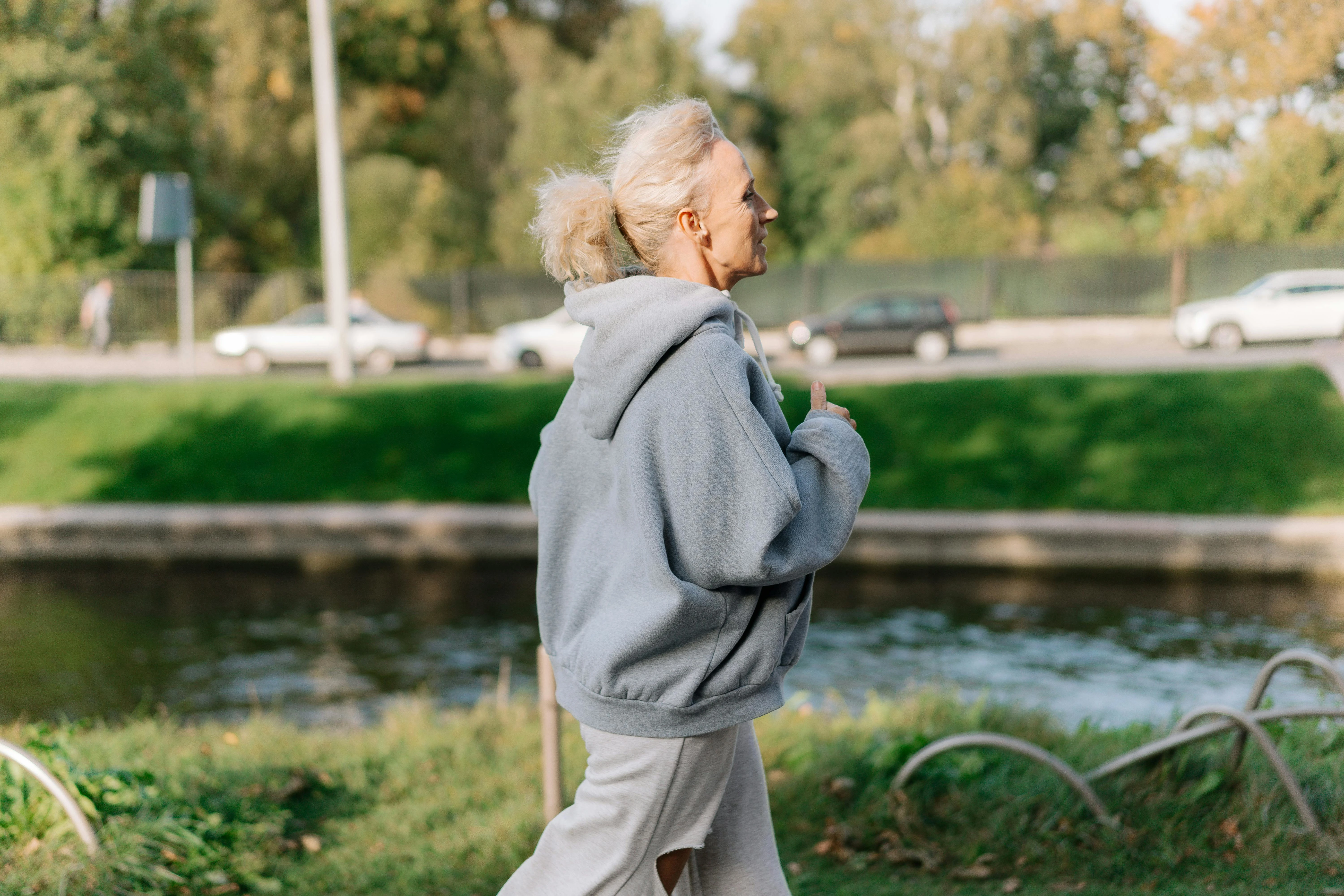 Une femme âgée en train de courir, chaussée de chaussures du Foot Care Center by Spronken Orthopedie en Belgique