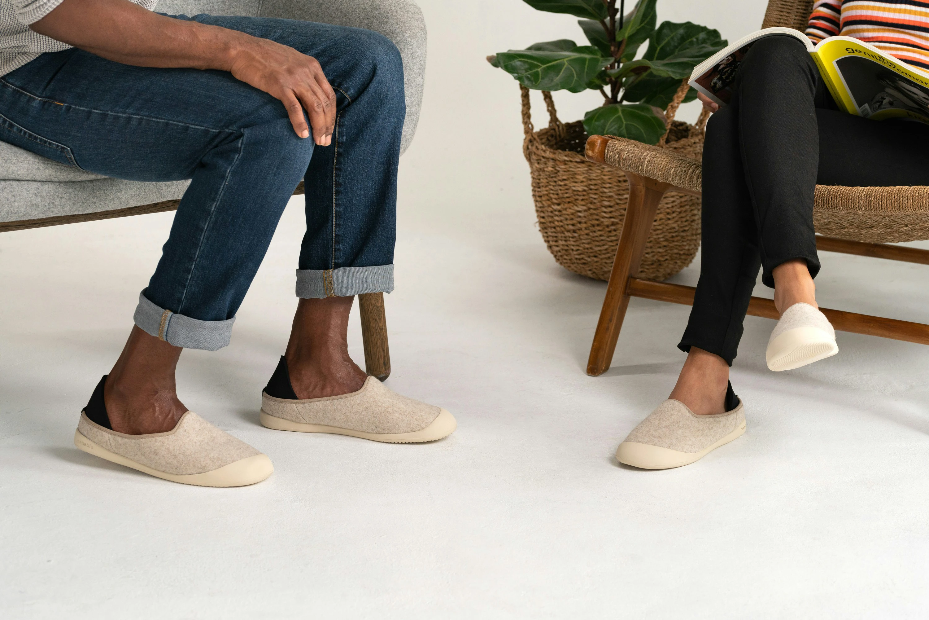 Deux personnes en conversation, chaussées de pantoufles orthopédiques et de chaussures d'intérieur sur mesure du Foot Care Center by Spronken Orthopedie.