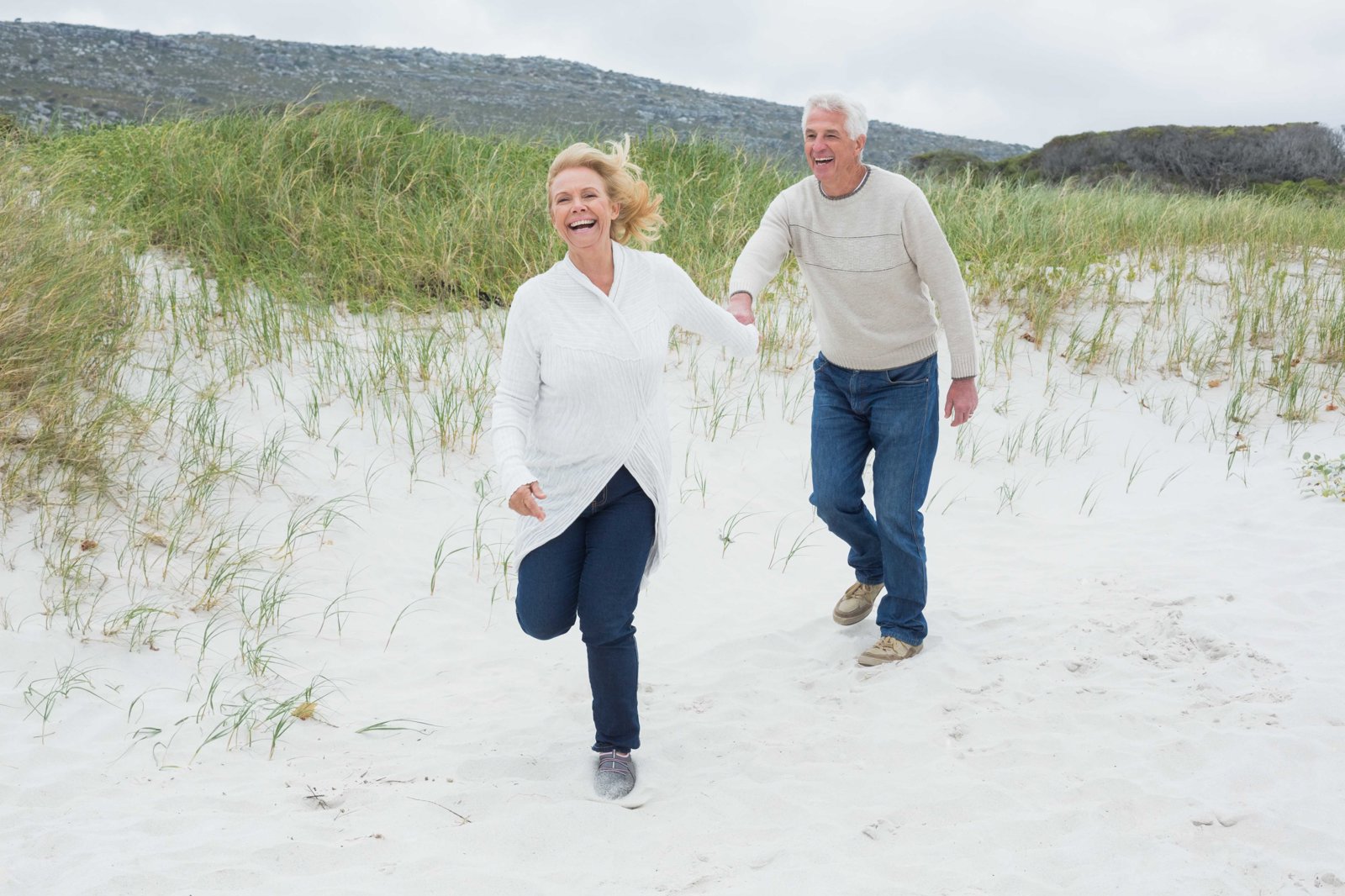 Cheerful Senior Couple Running Beach